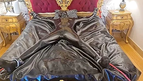 Latex-encased Woman Tied To Bed